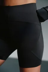 Calza biker deportiva negra, tiro alto, confeccionada en poliéster y elastano.