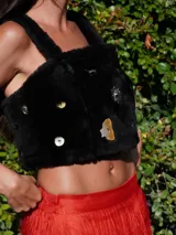 Top corto de corderito color crudo, con breteles y cierre con broches en la espalda. Decorado con pins y tachas variadas.