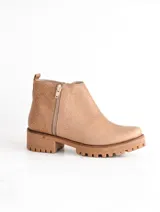 Bota corta color beige de cuero vacuno con suela de caucho y cierre lateral con cremallera.
