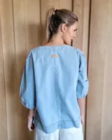 Blusa de denim oscuro con escote en V y mangas abullonadas.