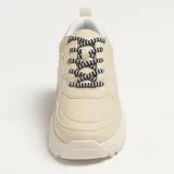 Zapatillas deportivas color beige con cordones a rayas en blanco y negro, suela de goma con plataforma y diseño chunky.