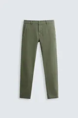 Pantalón chino color verde militar, corte skinny fit, con bolsillos laterales y traseros. Cierre frontal con cremallera y botón.
