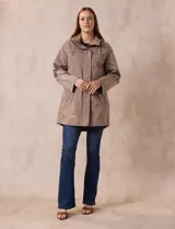 Campera impermeable color beige, marca Weatherproof, con capucha desmontable, cierre central oculto con botones a presión, bolsillos laterales con cierre y corte a la altura de la cadera.