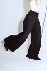 Pantalón de jean negro de tiro alto, corte wide leg y denim rígido.