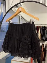 Minifalda negra de encaje con volados y cintura elastizada.