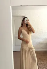 Vestido largo color amarillo pastel, con breteles finos y escote en V. La parte superior es de doble tela de microtul y la falda es amplia con volados.