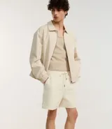 Bermuda de terciopelo color crema, corte runner, con cintura elástica, cordón ajustable y bolsillos laterales.