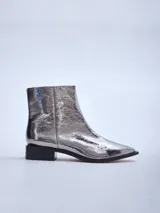 Bota corta plateada de cuero brillante con punta cuadrada y taco bajo negro.