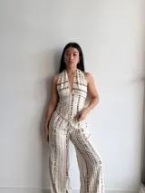 Top halter de mujer color beige con estampado tie-dye vertical en tonos marrones. El corpiño es corto y se ata en la espalda y el cuello.