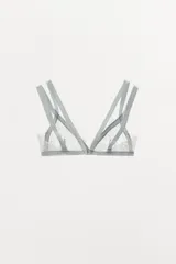 Bralette de encaje color gris con escote en V y doble tirante. Cierre trasero con gancho metálico.
