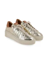 Sneaker de cuero color beige con suela elevada y cordones de algodón.
