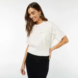 Camiseta blanca de algodón con cuello redondo y mangas cortas. Presenta un bolsillo en el pecho con dos lazos decorativos.