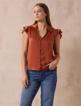 Camisa color ladrillo de satén, marca Alex & Lili. Cuello a la base con solapa, escote en V, apertura central con botones y sisa con volados.