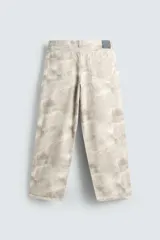 Pantalón de jean blanco, corte holgado y amplio en toda la pierna, tiro medio, tejido ligero, cinco bolsillos, efecto lavado y cierre frontal con cremallera y botón.