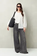 Bolso negro amplio tipo tote bag, confeccionado en poliuretano, con líneas minimalistas y diseño versátil.