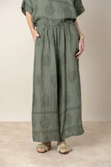 Pantalón palazzo de lino color crudo con estampado floral al tono, tiro alto y cintura elastizada.