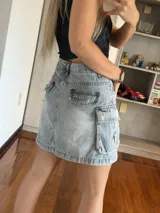 Minifalda de jean celeste con bolsillos cargo laterales y corte recto.