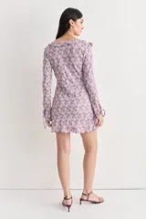 Vestido corto de encaje color lila con estampado floral, escote en V y volados.