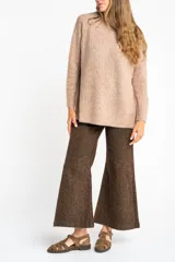 Sweater color beige de tejido texturado, con cuello redondo y mangas largas.