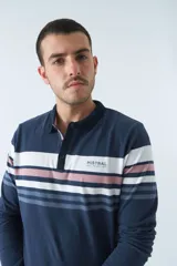 Remera cuello polo de manga larga color beige con rayas horizontales en verde, azul y blanco.