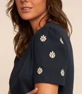 Blusa azul marino de algodón con cuello redondo y mangas cortas abullonadas con bordado floral.