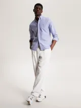Camisa celeste de corte regular Tommy Hilfiger, confeccionada en algodón Oxford con microestampado de puntos azules. Tiene cuello abotonado, manga larga y logo bordado en el pecho.
