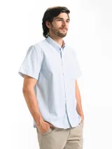 Camisa de hombre a cuadros celestes y blancos, de manga corta, con cuello abotonado y bolsillo en el pecho.