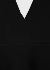 Top negro de tejido de punto fino con corte peplum, cuello de pico, tirantes anchos y espalda descubierta.