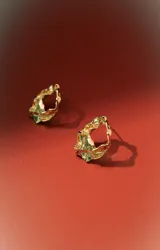 Aros de estilo orgánico, con forma irregular y textura martillada, en tono dorado.