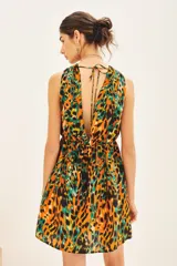 Vestido corto con estampado animal print en tonos naranja, negro y verde. Tiene escote en V, cintura elastizada y bolsillos laterales.