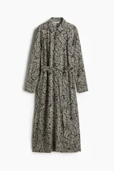 Vestido camisero midi de viscosa con estampado de hojas en blanco y negro, cuello camisero, botonadura frontal y cinturón ancho para atar extraíble. Mangas raglán largas con puños abotonados.