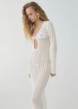 Vestido largo de crochet color blanco, con escote en V con lazo ajustable y mangas largas.