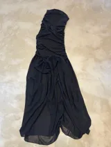 Vestido strapless negro con lunares blancos, confeccionado en jersey elastizado, con fruncido en laterales, y falda larga de gasa fruncida.