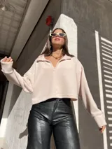 Buzo color rosa claro de tela Aspen con cuello polo y cierre parcial.