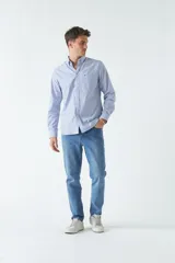 Camisa oxford celeste con rayas verticales blancas, de manga larga y corte regular. Tiene cuello abotonado, bolsillo en el pecho y logo bordado.