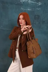 Cartera bandolera de símil cuero color marrón claro, con doble asa rígida y correa regulable. Presenta dos bolsillos frontales con cierre vertical y un bolsillo frontal con solapa y botón. Cuenta con dos divisiones internas.