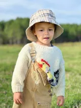 Sweater tejido de lana merino color crema con diseño de gallo bordado en la parte inferior izquierda.