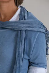 Sweater celeste de corte holgado con mangas 3/4 y cuello redondo. Incluye una bufanda fina del mismo color.