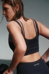Top deportivo negro con breteles finos cruzados en la espalda y banda inferior con el logo de la marca Caro Cuore.