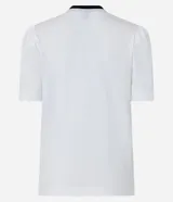 Blusa blanca de media malla de algodón, con cuello redondo con ribete negro y moña de terciopelo negra. Tiene mangas cortas abullonadas.