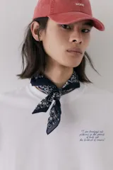Remera blanca de algodón con cuello redondo y estampado de texto en el pecho.