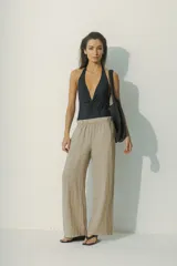 Pantalón de lino color beige, de corte palazzo con cintura elastizada.