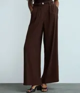 Pantalón femenino de tiro alto, color marrón oscuro, estilo wide leg con pliegues frontales y cintura fruncida con cinturón elástico.