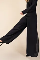 Pantalón palazzo negro de tejido fluido con aberturas laterales altas.