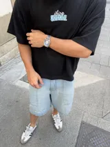 Remera marrón de corte holgado con estampado en la espalda que incluye la palabra 'Ibiza' y la frase 'It Itai' sobre bloques de hielo.