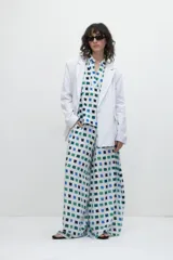 Blusa oversized con estampado geométrico en tonos azules y verdes, de manga corta y corte suelto.