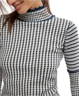 Remera de cuello alto con volados, mangas largas ajustadas y estampado de cuadros en blanco y negro.