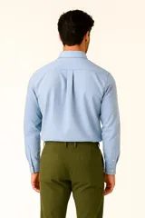 Camisa de lino color celeste, con cuello clásico, botones frontales y bolsillo en el pecho.