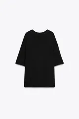 Remera blanca de punto liso, corte amplio, cuello redondo y manga corta.
