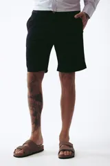 Bermuda de gabardina color negro, corte a la rodilla, con bolsillos laterales y traseros.